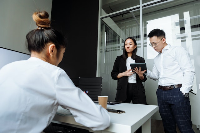 three property managers standing in an office discussing an account